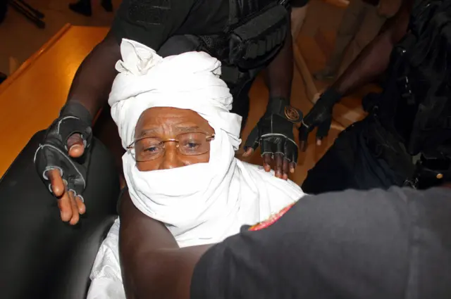 In this Monday July. 20, 2015 file photo, security personnel surround former Chadian dictator Hissene Habre inside the court in Dakar, Senegal.