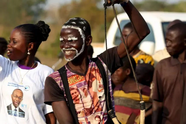 A man with face paint cheers presidential candidate Anicet Georges Dologuele