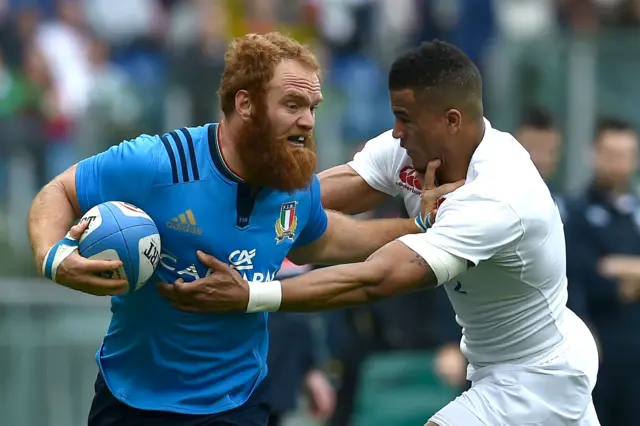 Leonardo Sarto is takled by England's wing Anthony Watson