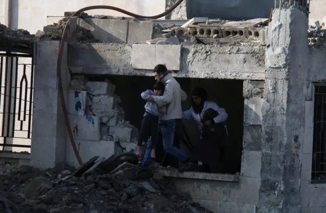 Child being rescued from damaged clinic in Azaz