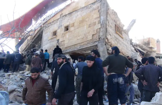 People gather outside damaged hospital in Maarat al-Numan