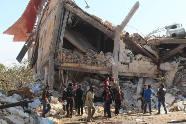 People gather outside damaged hospital in Maarat al-Numan