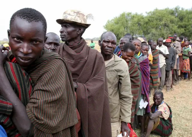 People from Karamojong tribe wait in line to vote at a polling station during the presidential elections in a village near town of Kaabong in Karamoja region, Uganda