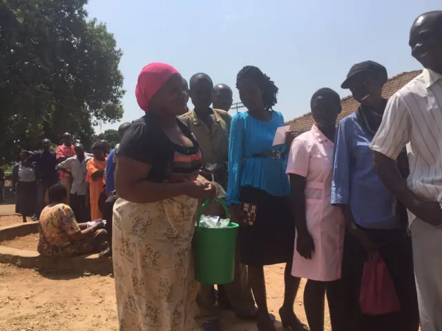 Woman selling water in a voter queue