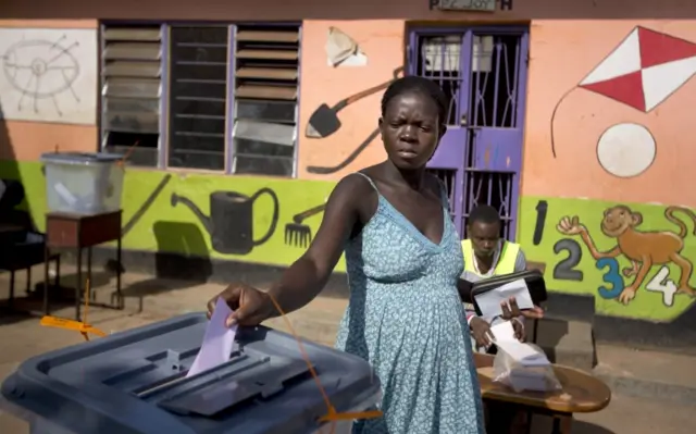 A Ugandan woman casts her vote at a polling station located at a school in Kampala, Uganda,