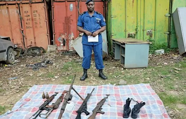 Policeman standing infront of guns