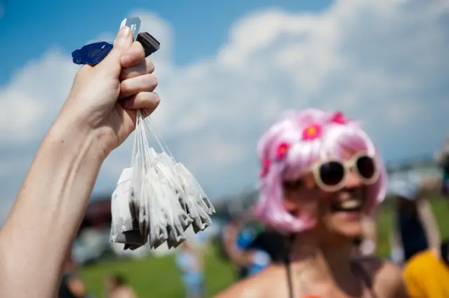 Woman holds up tea bags