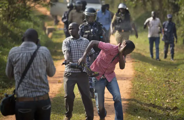 Photojournalist shields his eyes from pepper spray