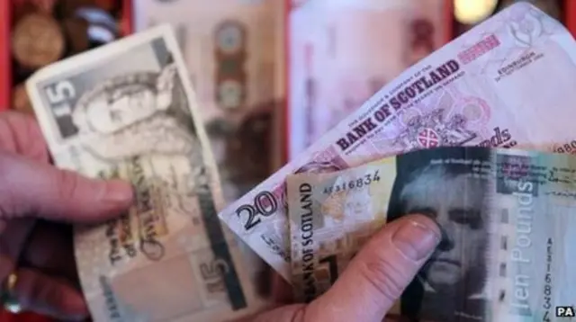 Hands shuffling Scottish bank notes