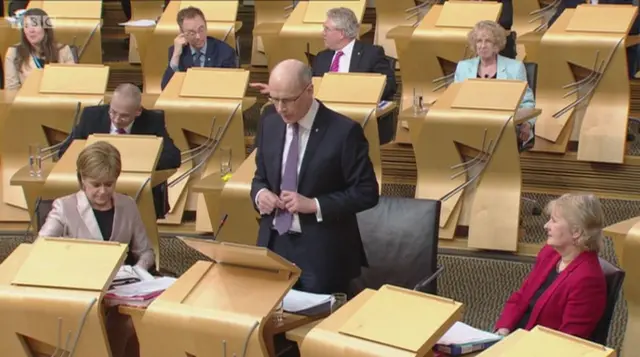 John Swinney addressing the chamber