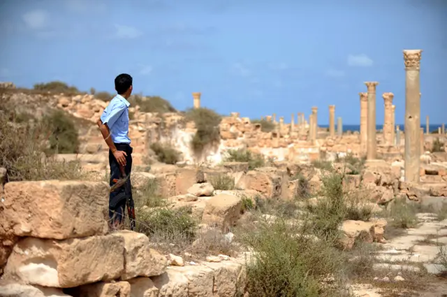 A Libyan officer with the tourist police patrols the Roman Temple in Sabratha on September 6, 2011 as Libyan archaeologists begin to inspect the country's priceless historical sites, hoping part of their cultural heritage and economic future has not been ruined by war.