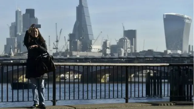 Woman taking a selfie on a London bridge