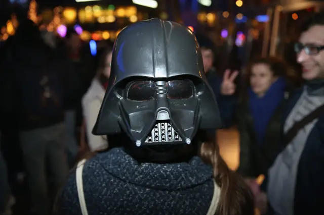 A Star Wars fans wears a Darth Vader mask