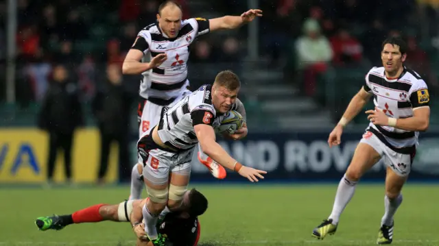 Ross Moriarty of Gloucester Rugby is tackled by Will Fraser of Saracens