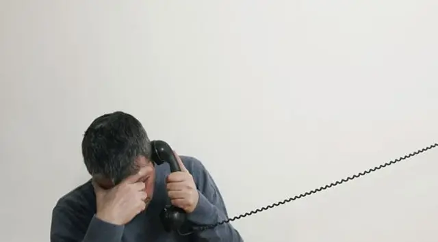 Man on the phone with his head in his hands