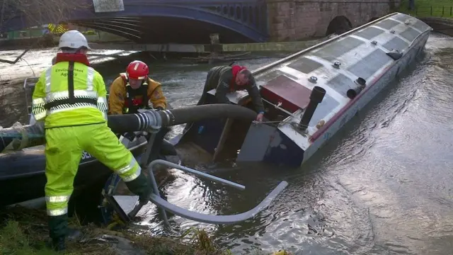 The Environment Agency and fire service personnel have been working together to pump water out of the partially sunken boat