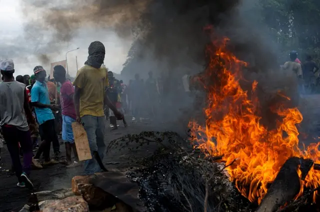 Protesters stand at a burning barricade in the Musaga neighbourhood of Bujumbura, Burundi, on May 5, 2015