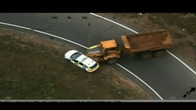 Aerial shot of dumper truck about to hit police car