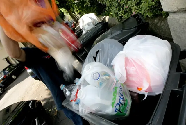 emptying rubbish into wheelie bin