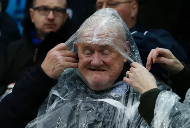 A Leicester fan wears a waterproof before the English Premier League football match between Manchester City and Leicester City at the Etihad Stadium