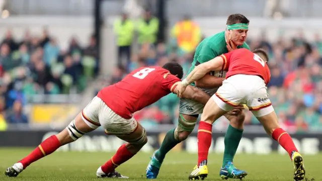 CJ Stander is tackled by Gareth Davies and Taulupe Faletau