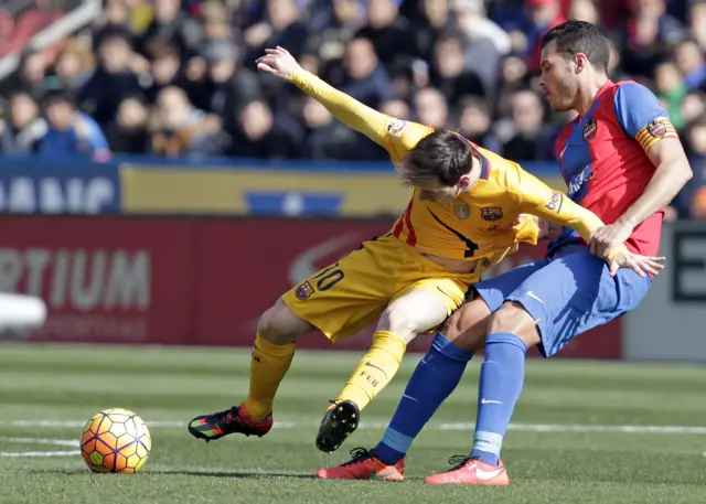 Lionel Messi is pulled back by David Navarro