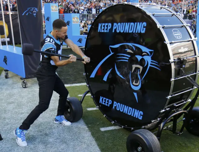 Stephen Curry bangs a large drum