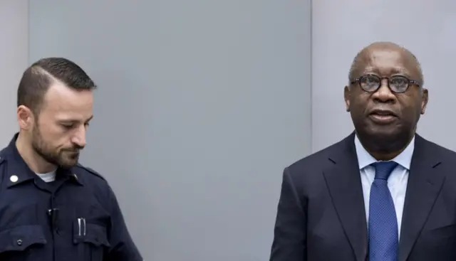 is file photo taken on January 28, 2016 shows former Ivory Coast president Laurent Gbagbo (R) arriving for the start of his trial at the International Criminal Court in The Hague