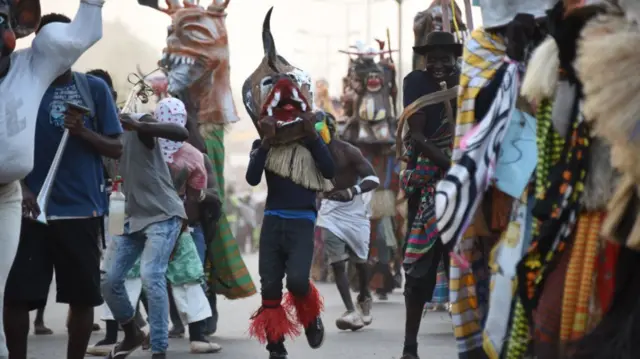 man with mask runs through the street