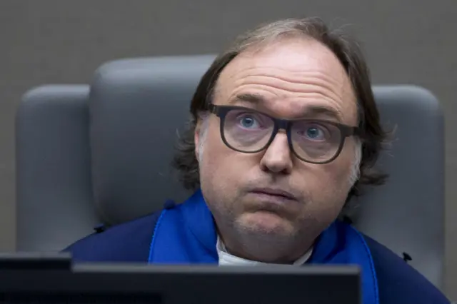 residing judge Cuno Tarfusser of Italy takes his seat as former Ivory Coast president Laurent Gbagbo and former minister Charles Ble Goude await the start of their trial at the International Criminal Court in The Hague on January 28, 2016