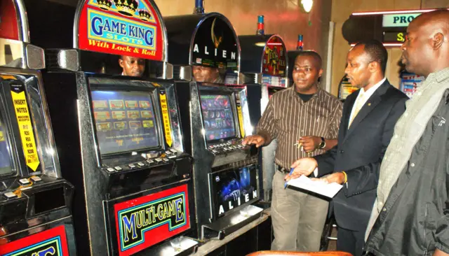 Officials looking at gambling machine