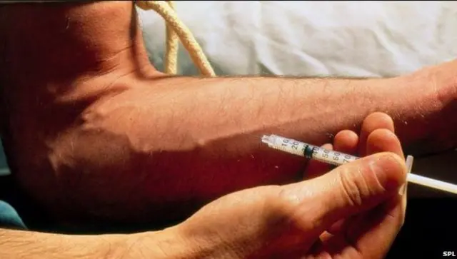 Man using needle to take blood from arm