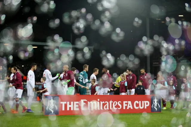 Players shake hands ahead of the match