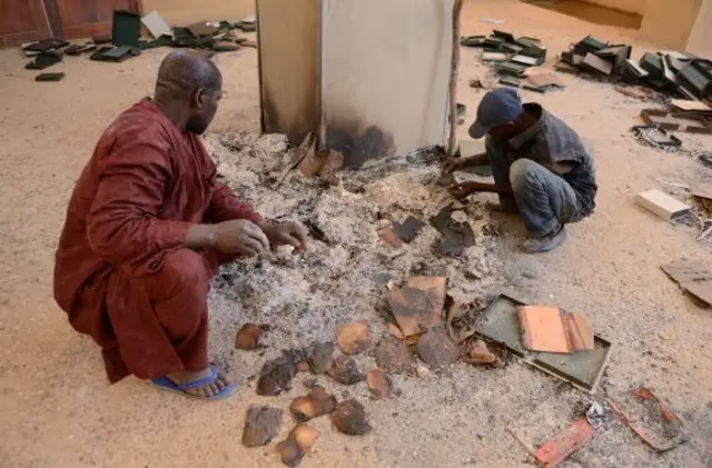 Men recover burnt ancient manuscripts at the Ahmed Baba Centre for Documentation and Research in Timbuktu on January 29, 2013