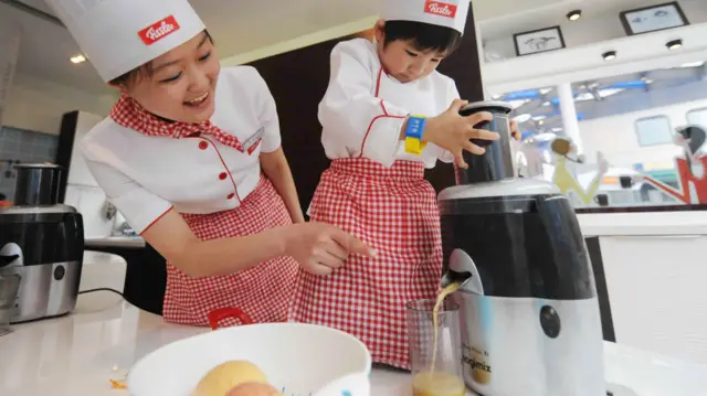 Two people use a food blender