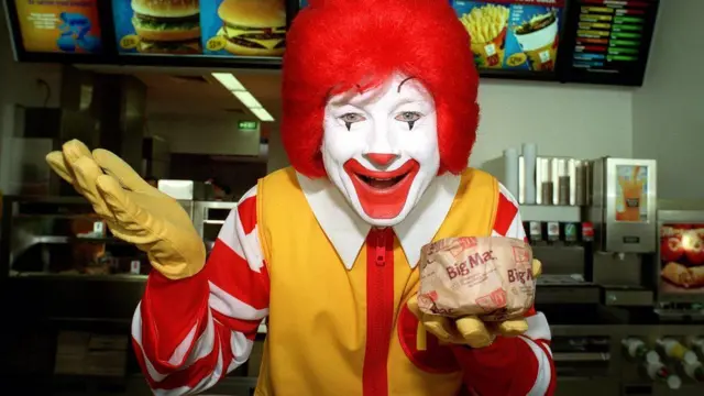 Ronald McDonald holding a burger