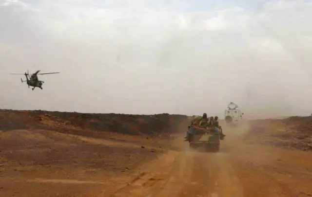 A picture taken on May 17, 2014 shows an helicopter of the French army escorting a vehicule transporting Mali's Prime Minister Moussa Mara from Gao to Kidal. Eight soldiers and 28 insurgents were killed in fighting on May 17 outside the regional governor's offices during Mara's visit to the desert town, the government said, adding that around 30 civil servants were being held hostage.