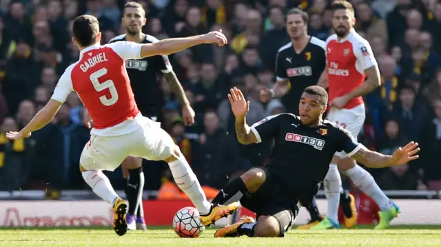 Gabriel and Troy Deeney challenge for the ball