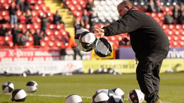 Charlton groundstaff clear beach balls from pitch