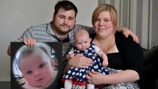 Beth and Martyn Amison, with 16-week-old Taymer, and a picture of Maison