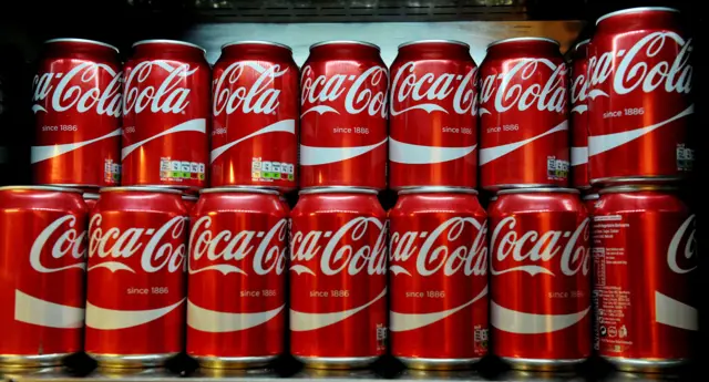 Coca Cola cans on a shelf