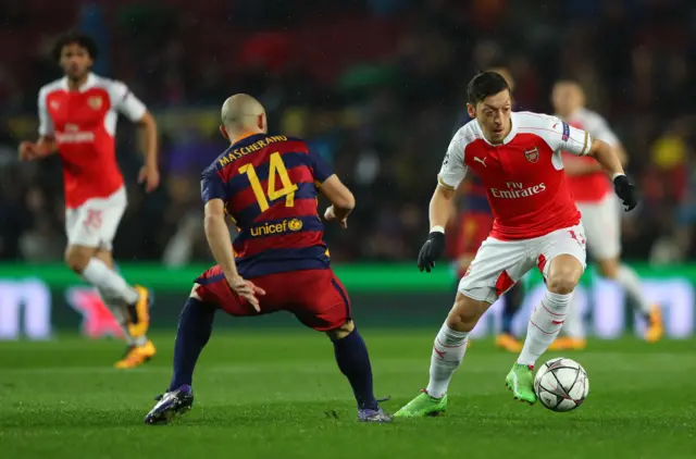 Mesut Ozil runs at Javier Mascherano