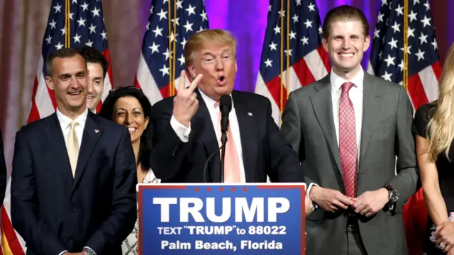 Republican U.S. presidential candidate Donald Trump stands between his campaign manager Corey Lewandowski (L) and his son Eric (R)