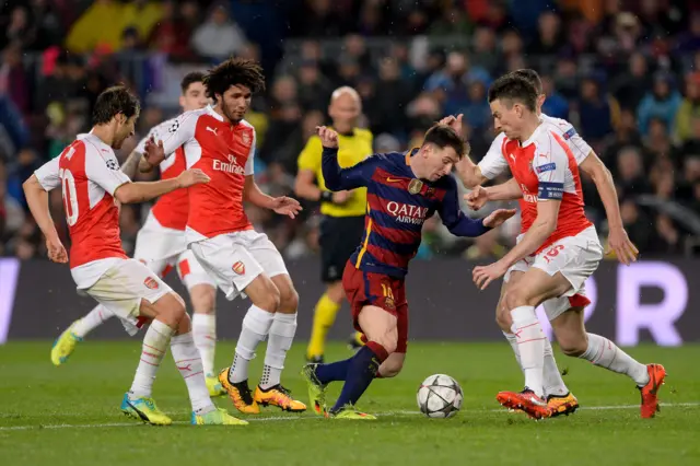 Lionel Messi dribbles as Arsenal's players surround him