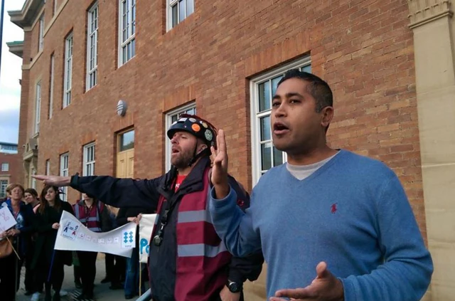 Derby city council leader Ranjit Banwait talks to school support staff at earlier protest