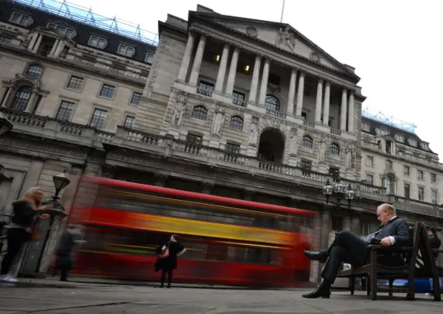 A man sits on a bench outside the Bank of England