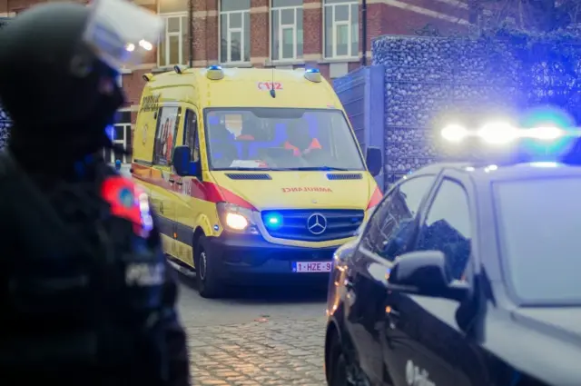 An ambulance car escorted by a civil police car leaves from the scene after an anti-terror operation in the Molenbeek neighborhood of Brussels, Belgium, 18 March 2016.