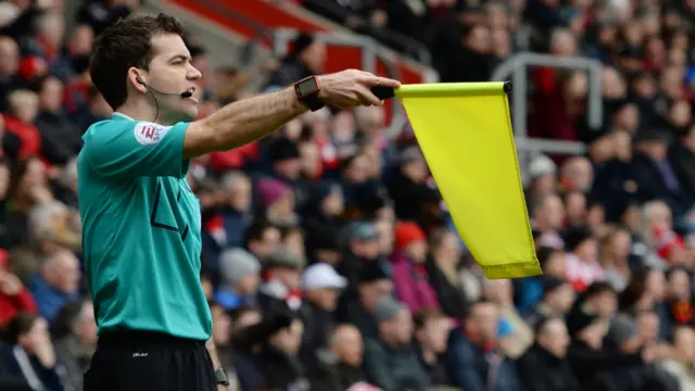 The assistant referee flags for offside