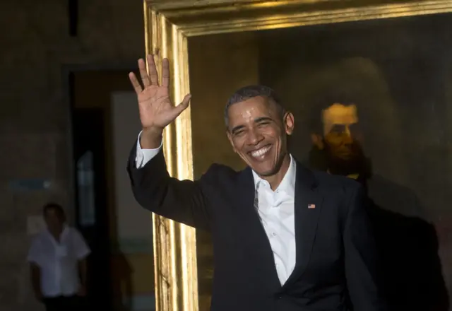 President Barack Obama waves to journalists next to a painting of President Abraham Lincoln at Havana"s City Museum during a visit to Old Havana, Cuba