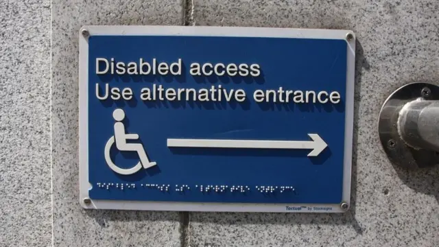 Sign telling wheelchair users to use another entrance